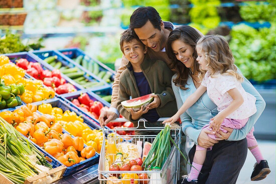 A family shopping in the fruit and vegetable aisle of a supermarket
